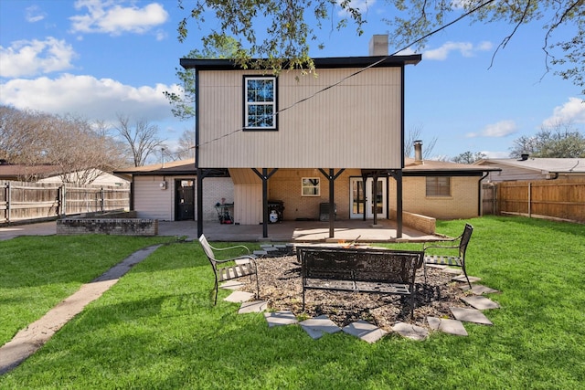 back of property with a yard, a patio area, brick siding, and a fenced backyard