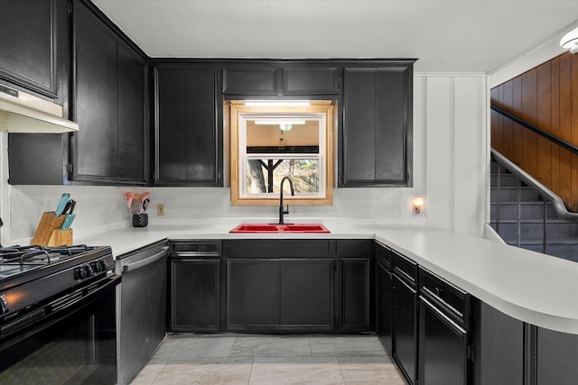 kitchen featuring light countertops, stainless steel dishwasher, a sink, black gas stove, and dark cabinetry