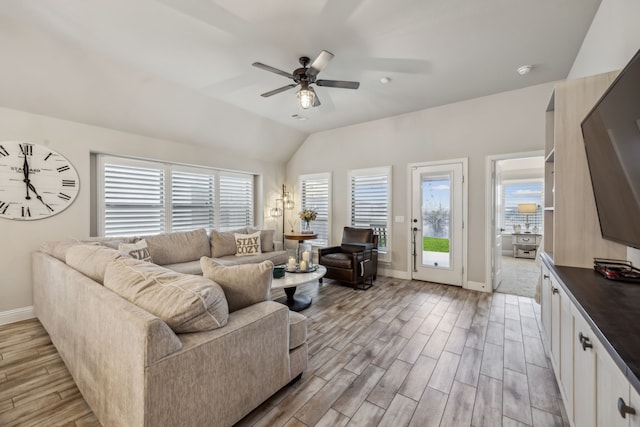 living room featuring lofted ceiling, ceiling fan, baseboards, and wood finish floors