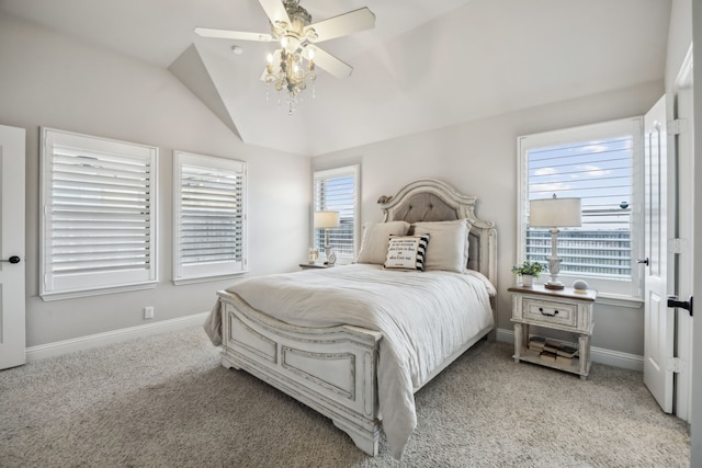 bedroom with lofted ceiling, multiple windows, baseboards, and light colored carpet