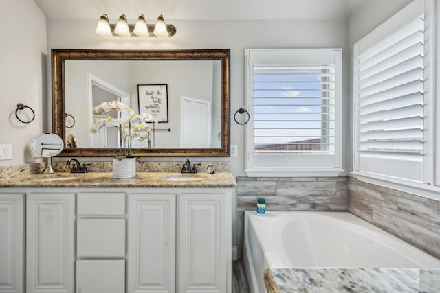 full bathroom with double vanity, a sink, and a bath