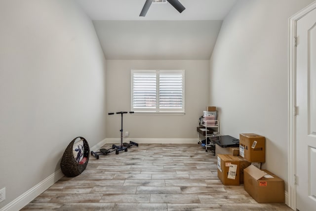 exercise room with lofted ceiling, ceiling fan, wood finished floors, and baseboards