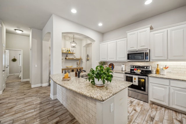 kitchen featuring stainless steel appliances, wood tiled floor, a sink, and tasteful backsplash