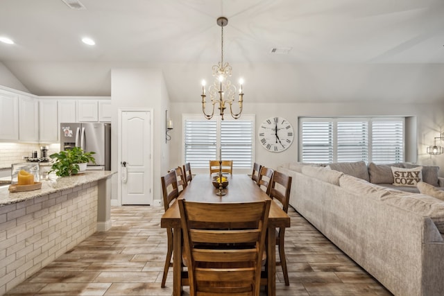 dining space featuring recessed lighting, visible vents, an inviting chandelier, wood tiled floor, and vaulted ceiling