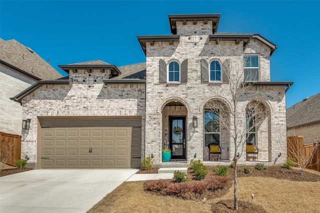 view of front of home with brick siding, concrete driveway, an attached garage, and fence