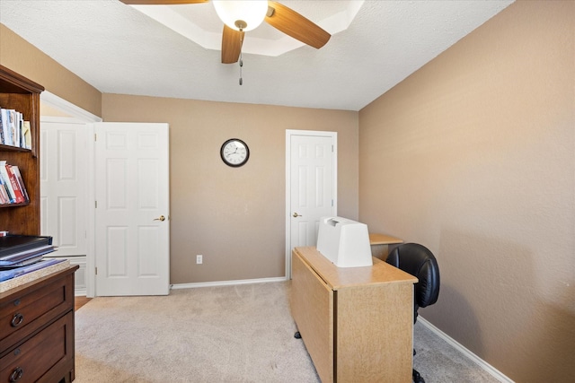 office space with baseboards, a ceiling fan, and light colored carpet