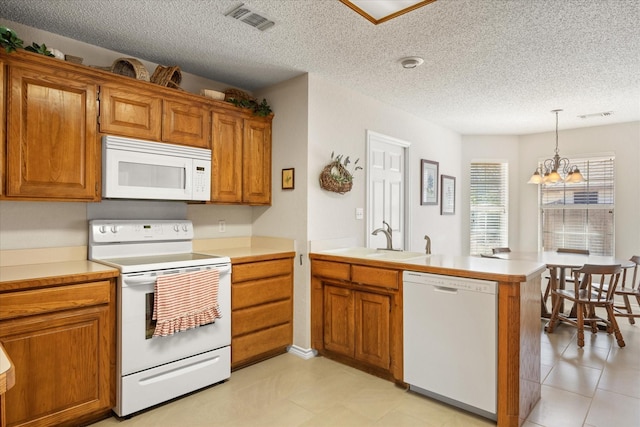 kitchen featuring light countertops, brown cabinetry, a sink, white appliances, and a peninsula