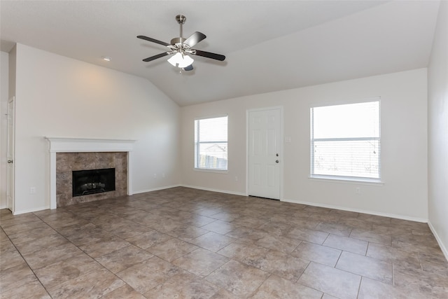 unfurnished living room featuring ceiling fan, baseboards, vaulted ceiling, and a tile fireplace