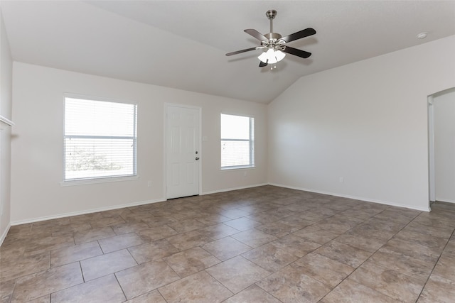 spare room with baseboards, vaulted ceiling, and a ceiling fan