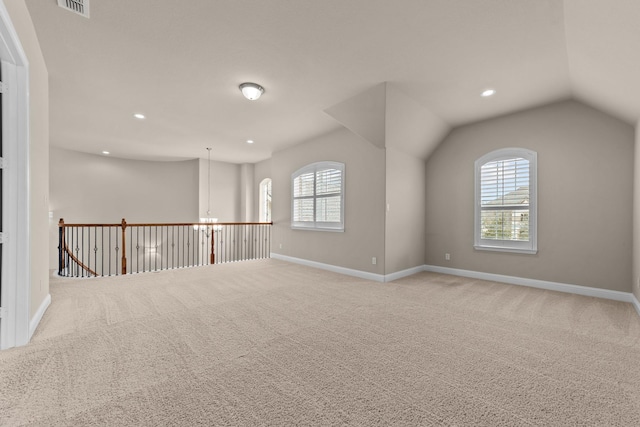 carpeted empty room featuring lofted ceiling, recessed lighting, baseboards, and visible vents