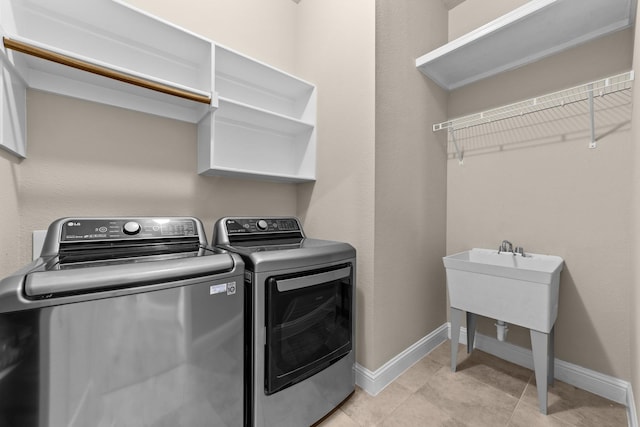 washroom with laundry area, baseboards, and independent washer and dryer