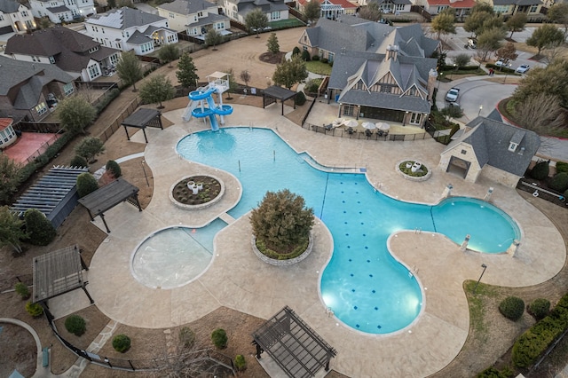 view of pool with a patio area, a water play area, a water slide, and a residential view