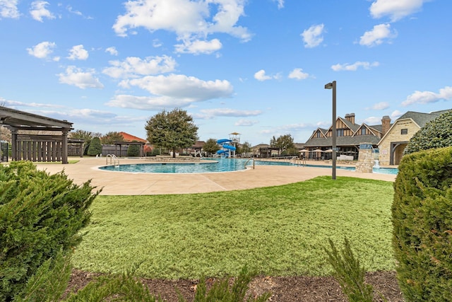 community pool featuring a patio, a lawn, and fence