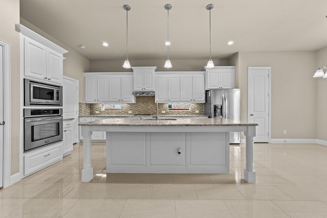 kitchen with under cabinet range hood, decorative backsplash, appliances with stainless steel finishes, and white cabinets