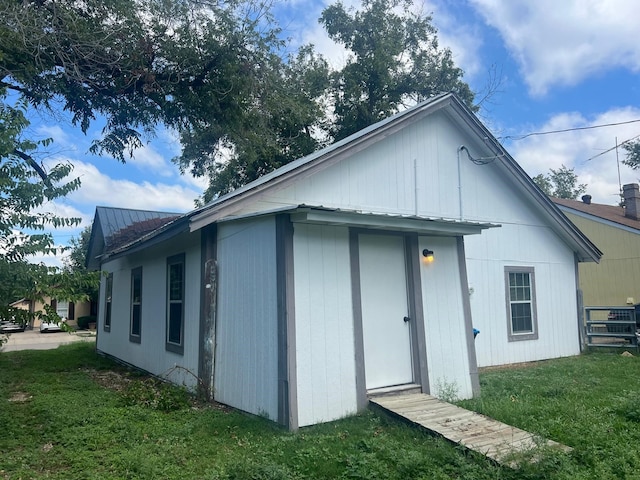 view of side of home with metal roof and a yard