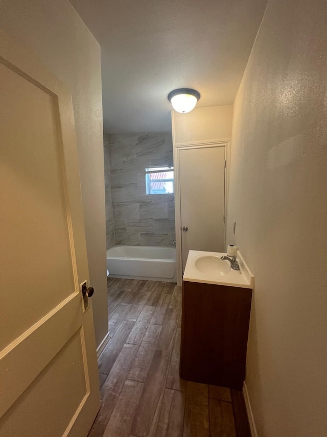 full bathroom featuring shower / washtub combination, wood finished floors, vanity, and baseboards