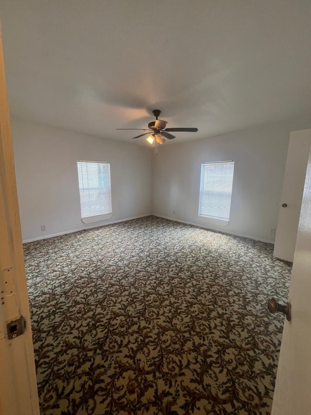 unfurnished room with carpet flooring, a ceiling fan, and baseboards