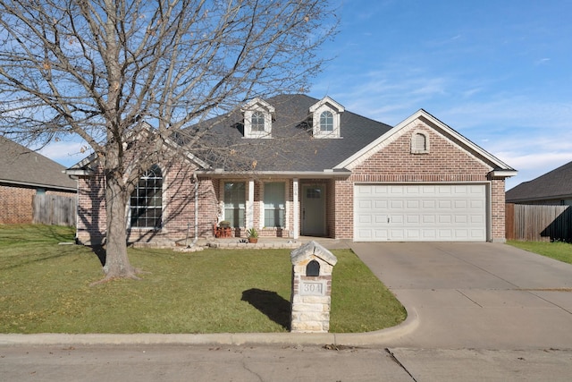 view of front of home featuring driveway, a garage, fence, a front yard, and brick siding