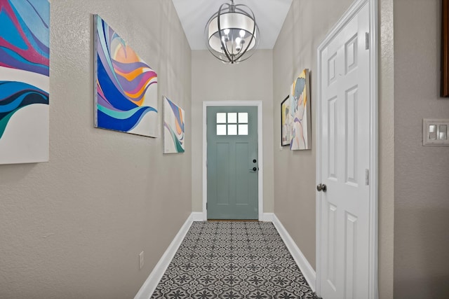 doorway with a chandelier and baseboards