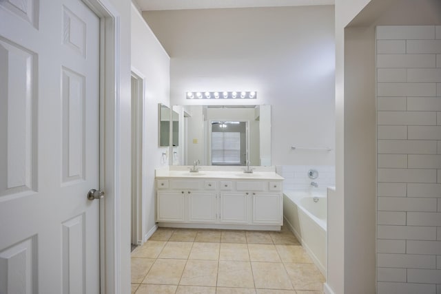 bathroom featuring double vanity, tile patterned flooring, a sink, and a bath