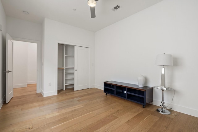 bedroom featuring baseboards, a closet, visible vents, and wood finished floors