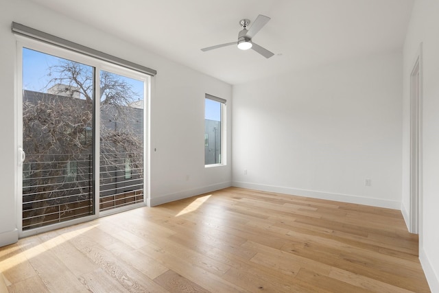 empty room with a ceiling fan, light wood-style flooring, and baseboards