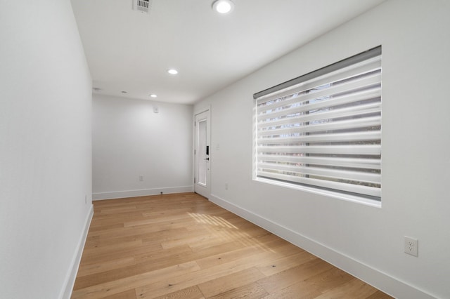 empty room with light wood-type flooring, visible vents, baseboards, and recessed lighting