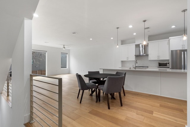 dining space with light wood finished floors, a toaster, ceiling fan, and recessed lighting