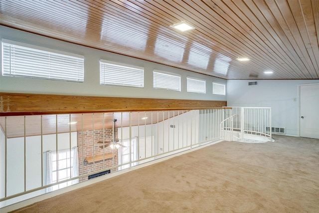 carpeted empty room featuring wooden ceiling, visible vents, and a ceiling fan