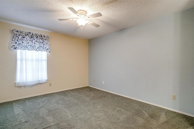 unfurnished room with ceiling fan, baseboards, dark colored carpet, and a textured ceiling