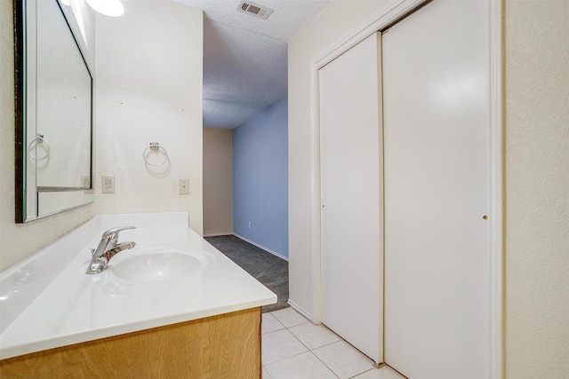 bathroom featuring vanity, visible vents, a textured ceiling, and tile patterned floors