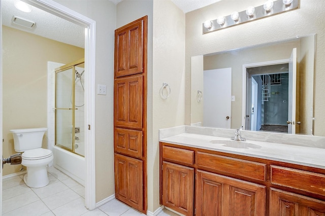 bathroom featuring visible vents, toilet, combined bath / shower with glass door, vanity, and tile patterned floors