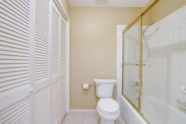 bathroom with a closet, toilet, enclosed tub / shower combo, a textured ceiling, and tile patterned flooring