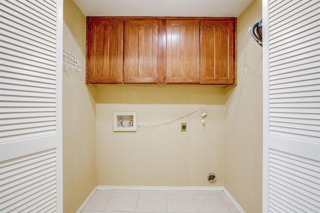 washroom with light tile patterned flooring, washer hookup, baseboards, cabinet space, and electric dryer hookup