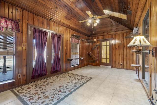 foyer entrance with wooden ceiling, ceiling fan, stairs, vaulted ceiling, and wood walls