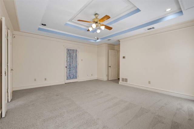 spare room featuring ornamental molding, carpet flooring, a raised ceiling, and visible vents