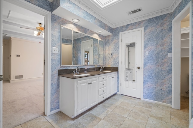 full bathroom featuring ornamental molding, a sink, visible vents, and wallpapered walls