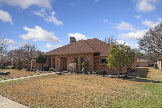 view of front facade featuring central AC unit, brick siding, a chimney, and a front yard