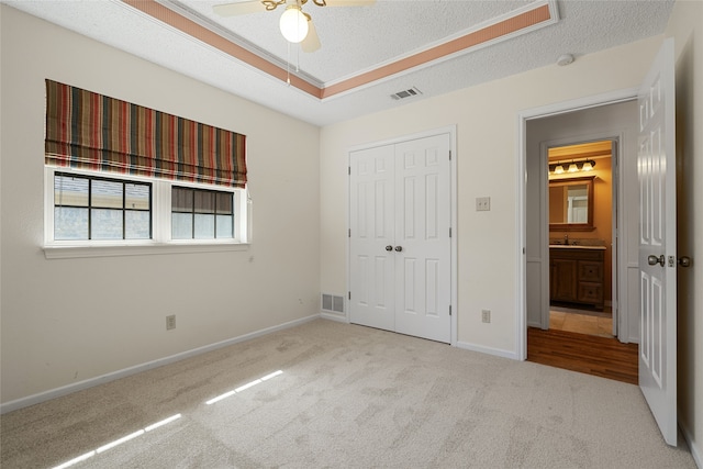 unfurnished bedroom with carpet, a closet, visible vents, and a textured ceiling