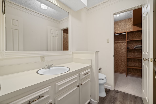 bathroom featuring a textured ceiling, vanity, wood finished floors, and toilet