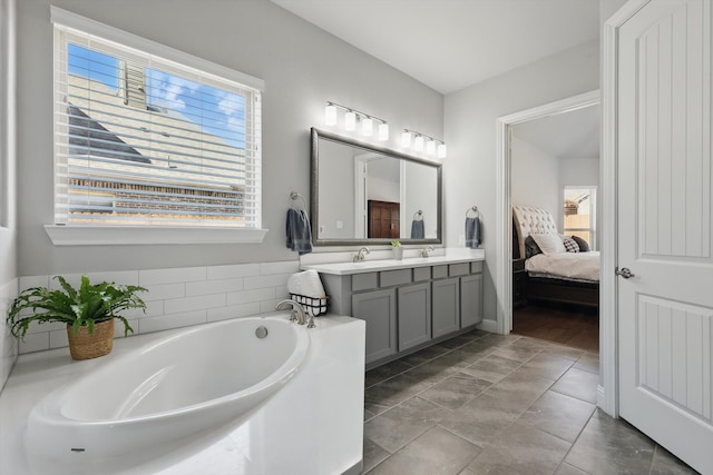 ensuite bathroom with a sink, ensuite bathroom, a garden tub, and double vanity