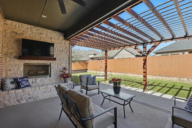 view of patio with an outdoor living space with a fireplace, a fenced backyard, and a pergola