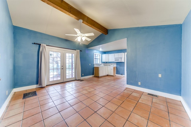 unfurnished living room with lofted ceiling with beams, light tile patterned floors, visible vents, and french doors