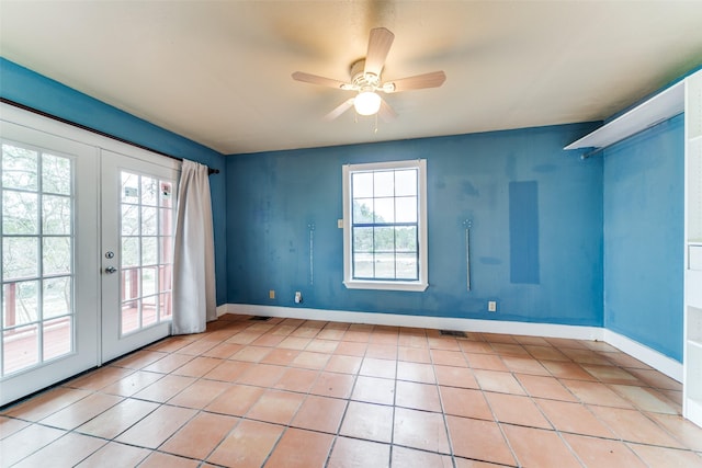 unfurnished room featuring a healthy amount of sunlight, light tile patterned floors, baseboards, and french doors