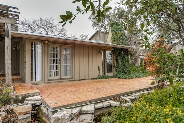 back of property with a patio area, a standing seam roof, metal roof, and french doors