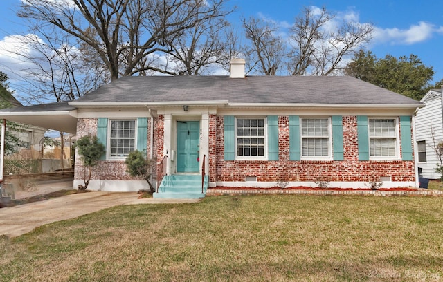 view of front of house with a chimney, a front lawn, concrete driveway, and brick siding