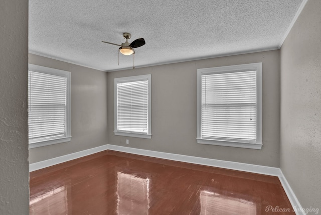 spare room with baseboards, a ceiling fan, a textured wall, wood finished floors, and a textured ceiling