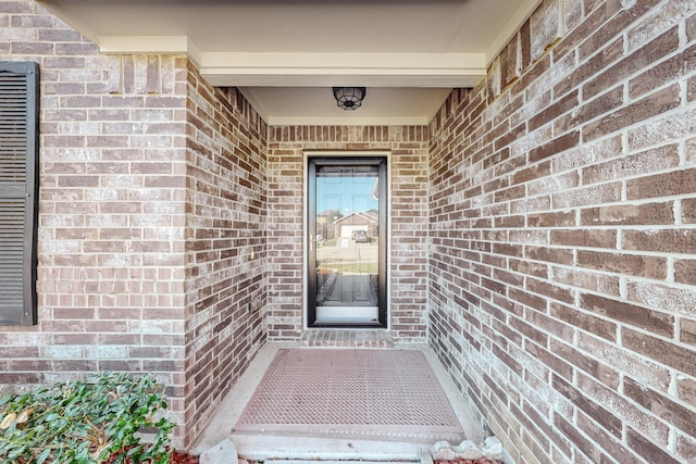 property entrance featuring brick siding