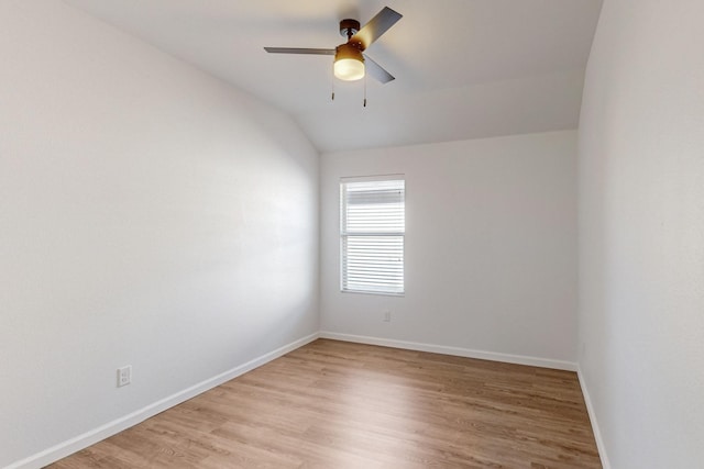 spare room featuring lofted ceiling, ceiling fan, light wood-type flooring, and baseboards