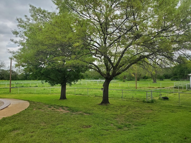 view of yard featuring fence and a rural view